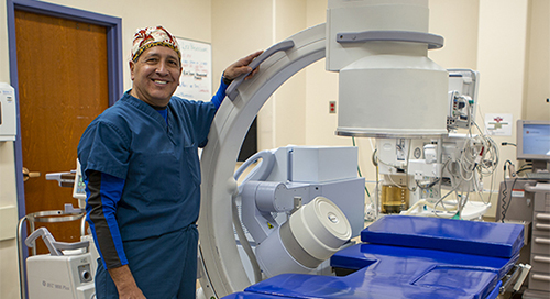 Dr. Stephen Lucero standing next to the Holy Cross Hospital Lithotripsy machine.