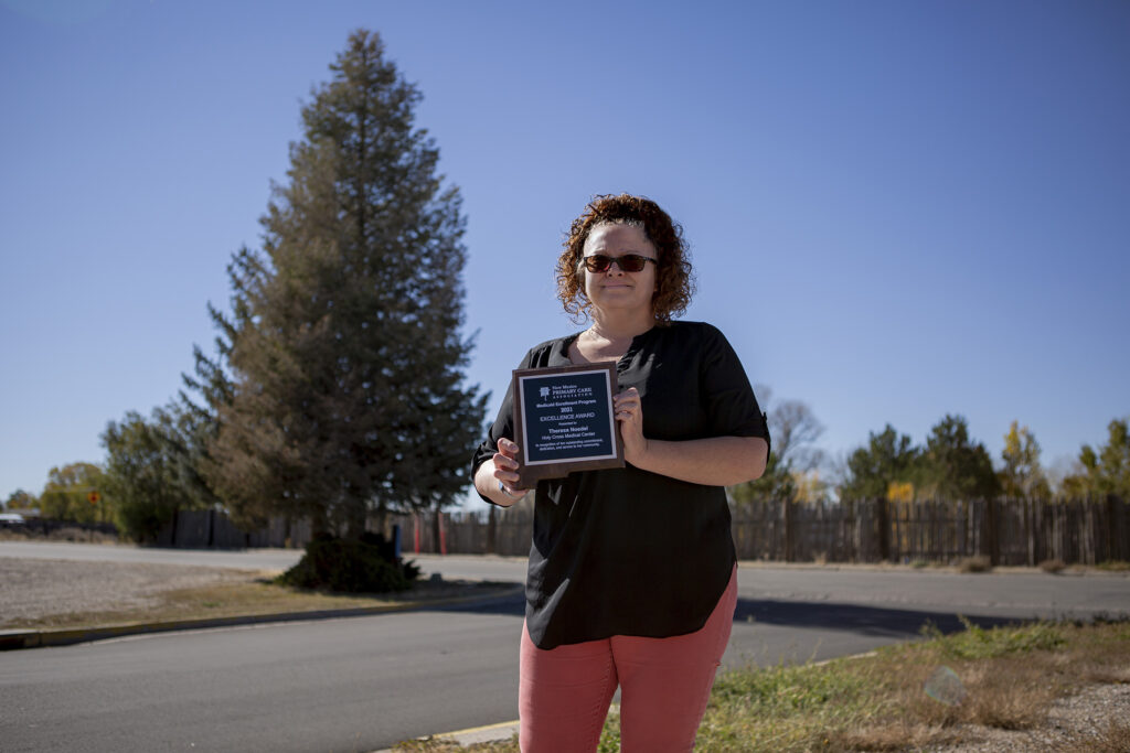 Theresa Noedel holding her excellence award from the NMPCA